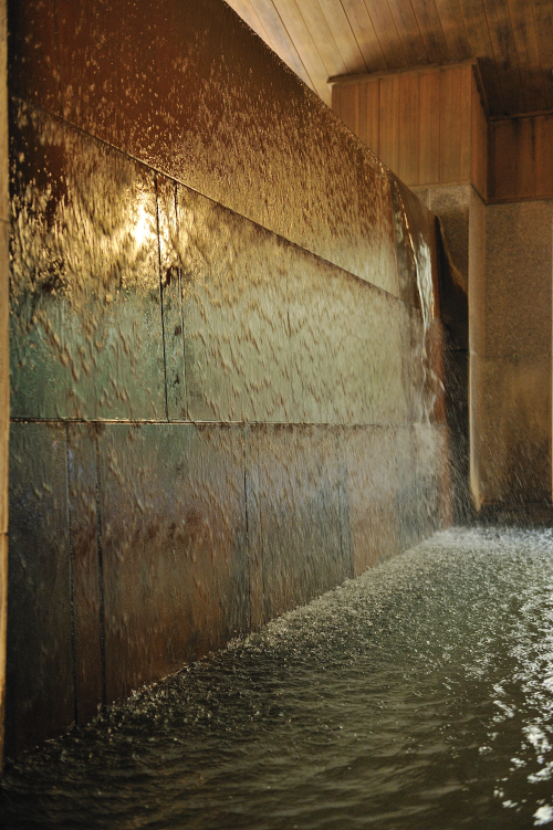 大浴場の壁から溢れでる温泉